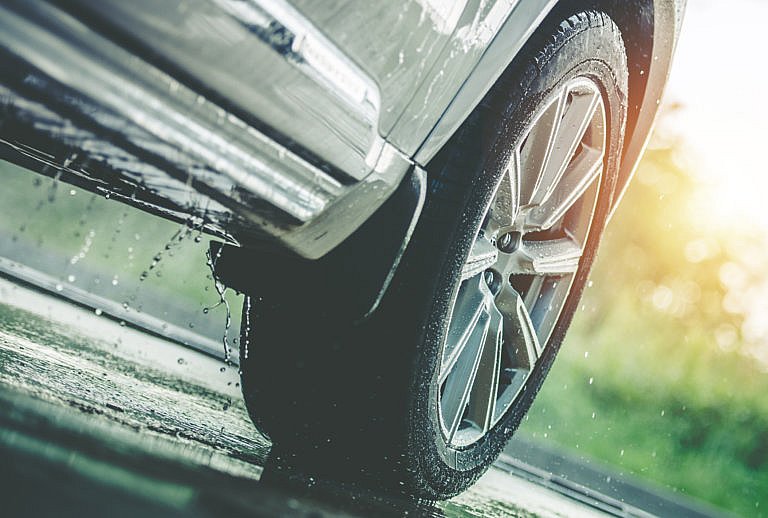 Someone driving a car in the rain, experiencing water leaks.