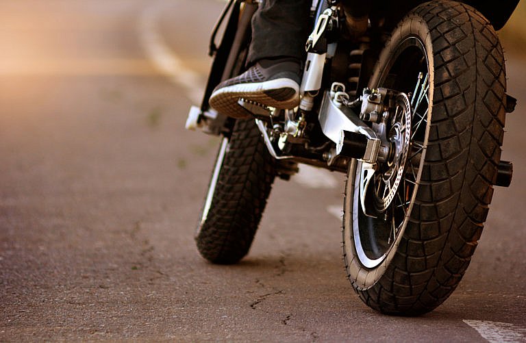 A motorcyclist on a paved road, shot from a low angle.