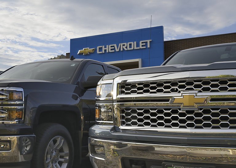 The Chevrolet logo and name are visible on the dealership building in the background.