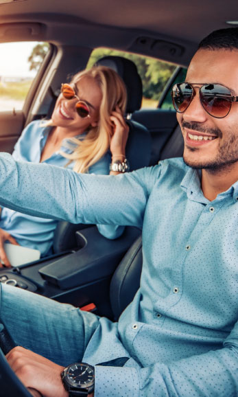 Smiling couple in front seat of their car