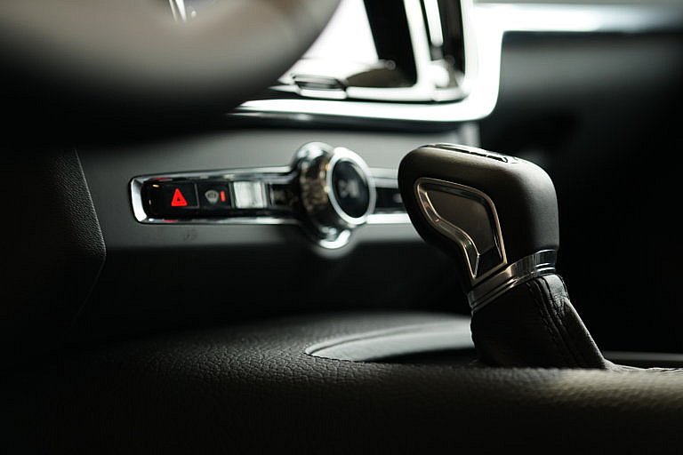 Close-up of a modern car's interior, showing the gear shift and dashboard controls.