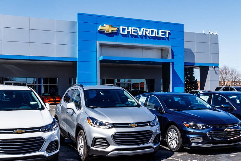 Chevrolet dealership with new cars parked in front.