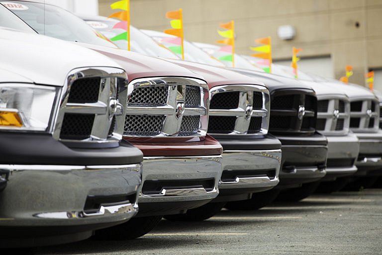 Front row view of multiple Dodge Ram trucks parked at a dealership.