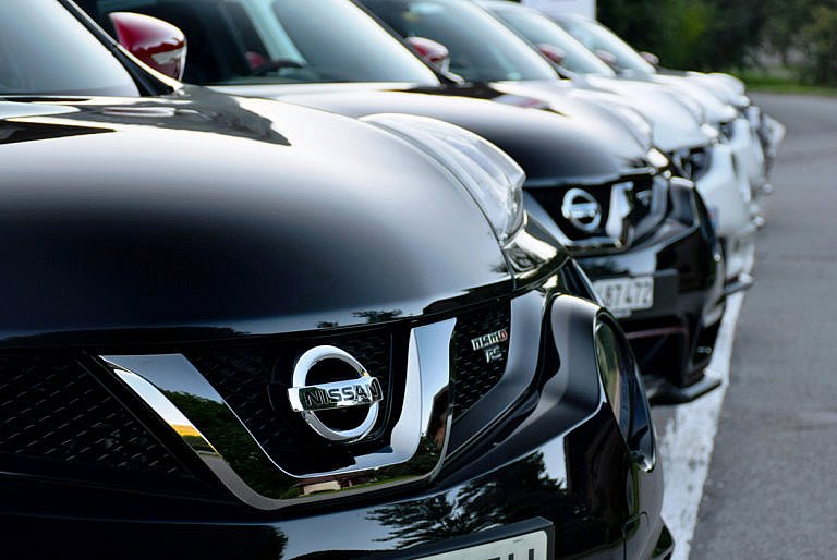 A row of Nissan SUVs, with the front car's grille and logo in sharp focus.