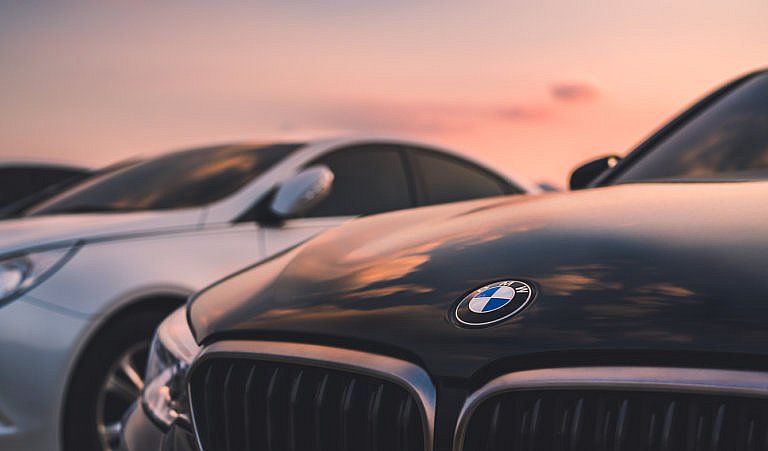 Close-up of BMW car grille and logo at sunset.