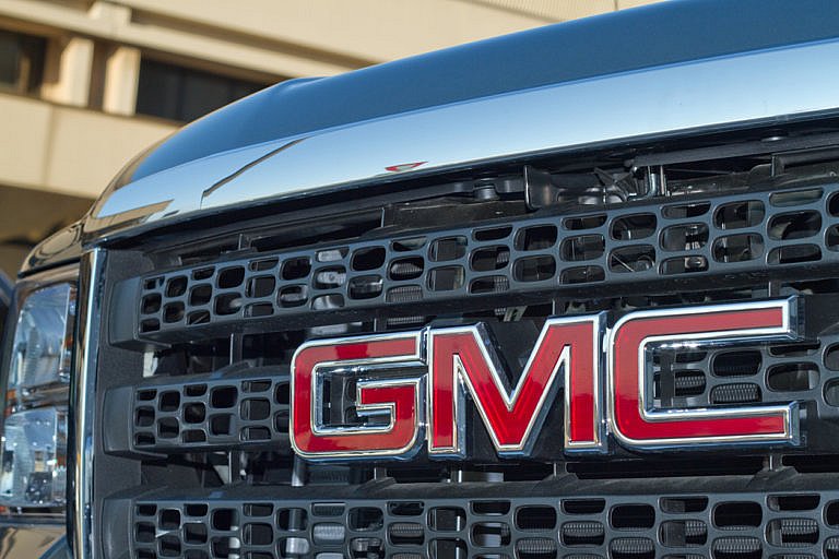 Close-up of a GMC truck grille with red GMC logo.