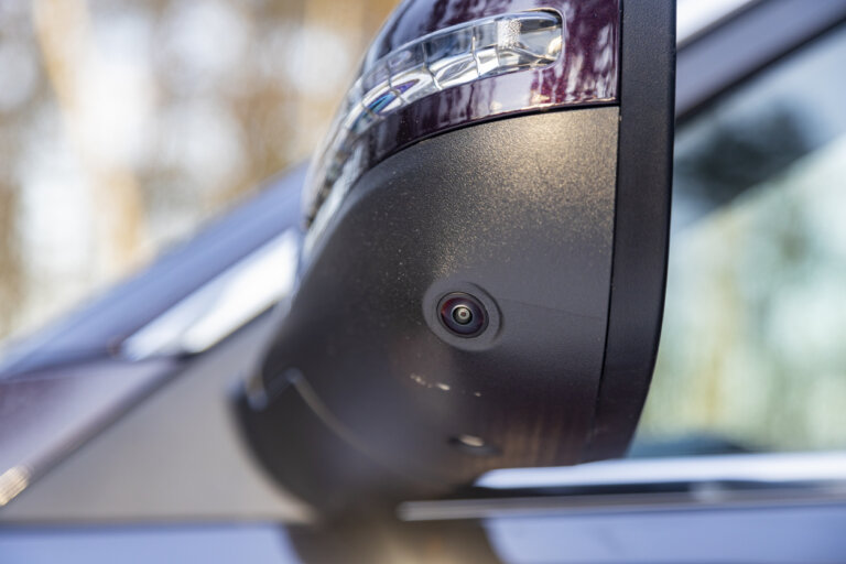 A close-up of a Ford truck mirror with a built-in camera.