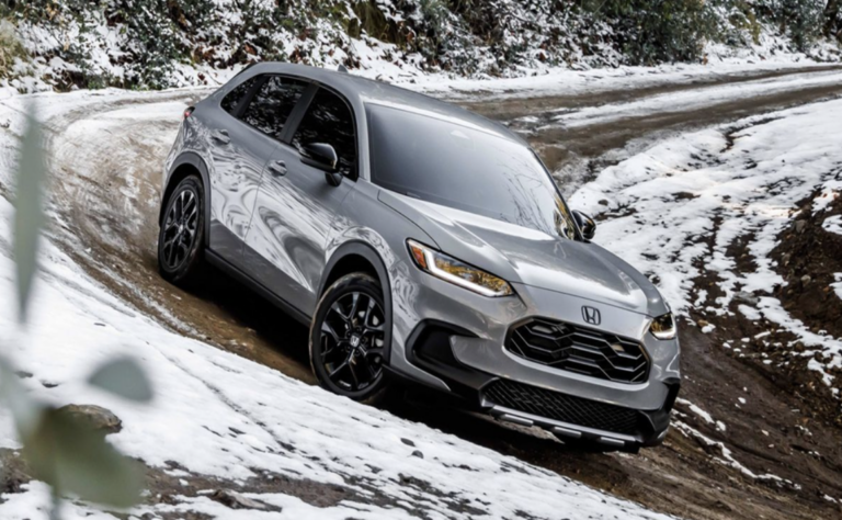 A sleek silver Honda HR-V is expertly navigating a snowy, off-road track.