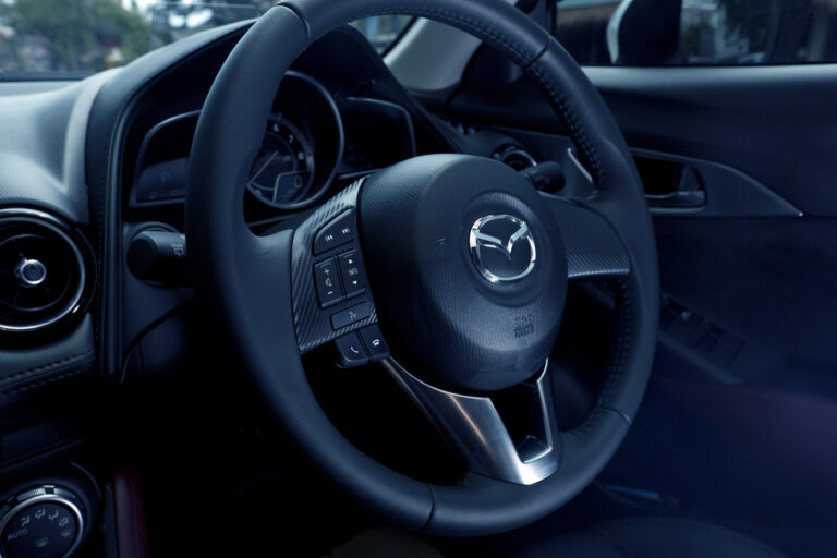 Interior view of a Mazda car steering wheel.
