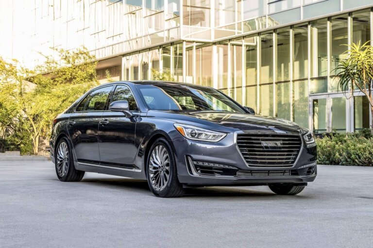 Luxury black Genesis sedan parked in front of a modern glass building