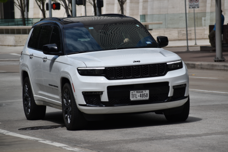 White Jeep Grand Cherokee driving in city