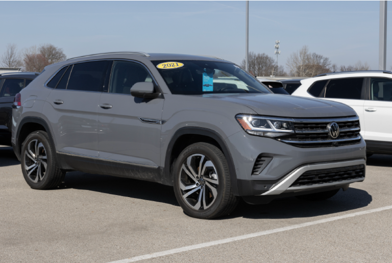 A gray 2021 Volkswagen Atlas is parked in a car lot on a sunny day.
