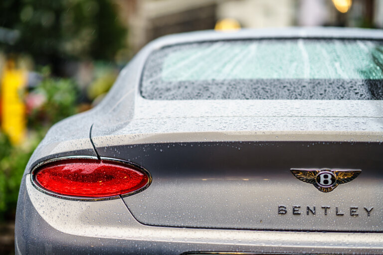A car rear window and trunk covered with raindrops.