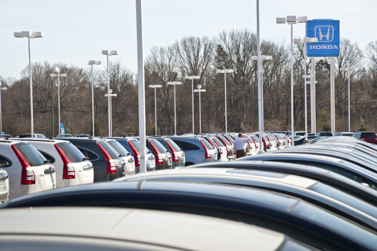 A wide shot of a Honda dealership lot in the Philippines, filled with rows of new vehicles under a clear sky.