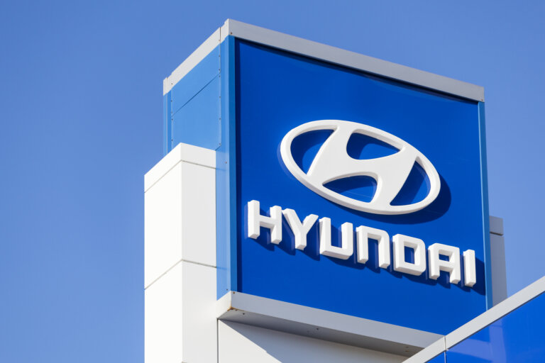 Hyundai dealership sign with logo on a blue background against clear sky