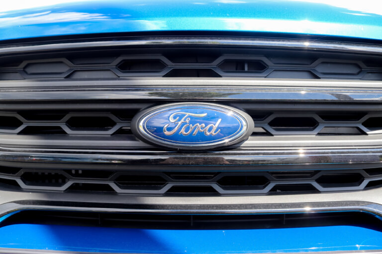 A close-up of the Ford logo on a blue vehicle grille.