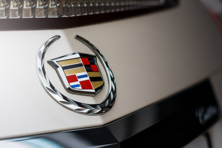 A close-up shot of the Cadillac logo on the front of a vehicle, highlighting the crest and wreath design.