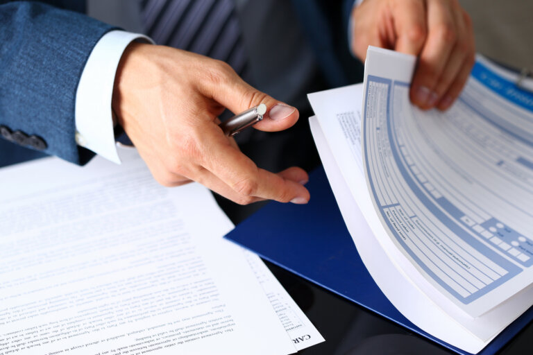 Businessman reviewing and signing documents with a pen in hand