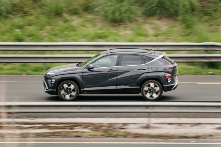A black Hyundai Kona driving on the highway.