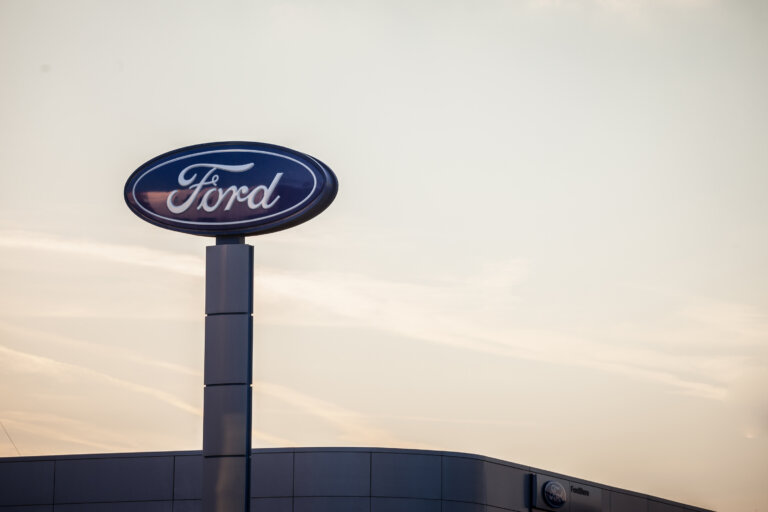 A Ford dealership sign stands tall against the evening sky.