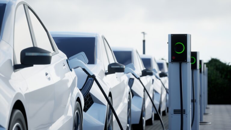 White electric cars charging at a station