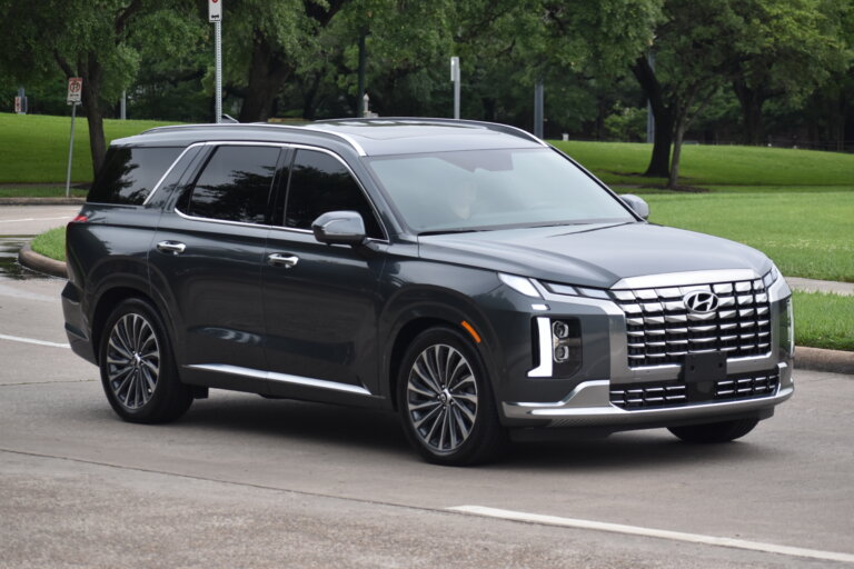 Dark gray Hyundai SUV driving on a suburban street