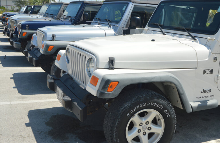 A row of Jeep Wrangler SUVs parked in a lot.