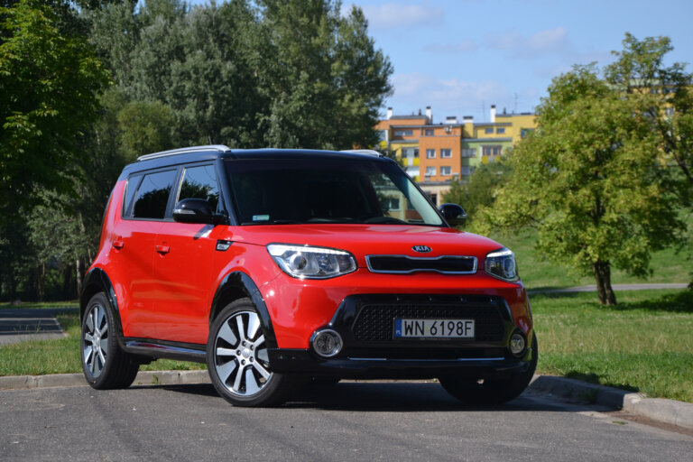 A red Kia Soul compact car is parked outdoors.