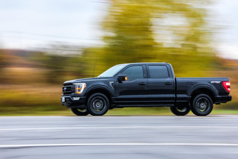A black Ford Bronco is driving on the road.