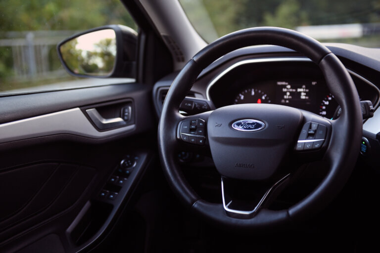 Interior view of a Ford vehicle with focus on the steering wheel and dashboard.