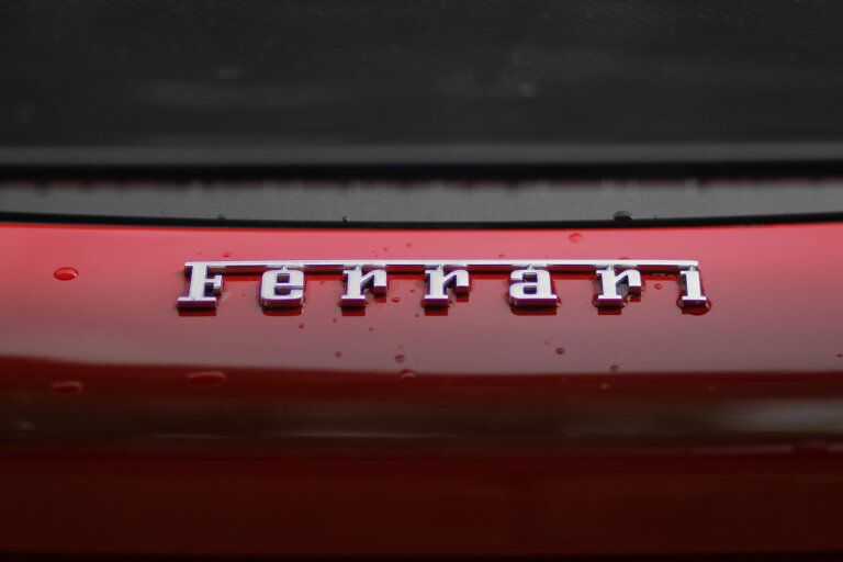Ferrari logo on a red car trunk with raindrops