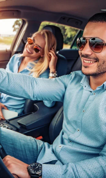 Smiling couple in front seat of their car