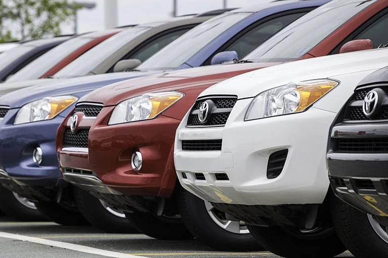 A row of parked Toyota RAV4 SUVs in various colors.