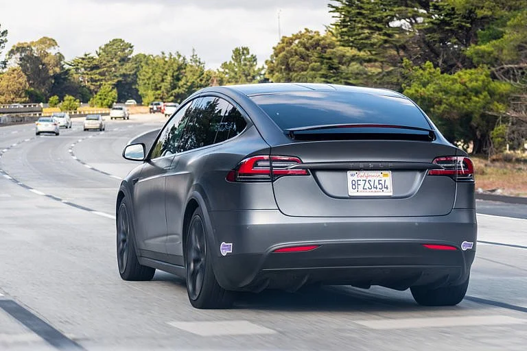A Tesla Model X is driving down the highway.