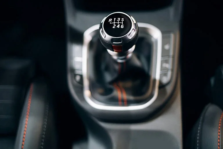 A close-up view of a manual gear shift inside a car.