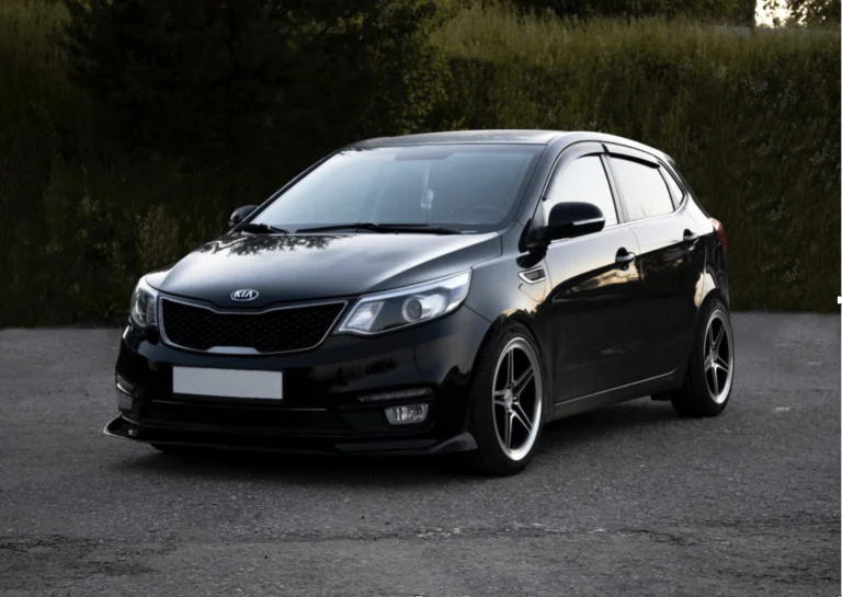 A black Kia Rio hatchback parked outdoors.