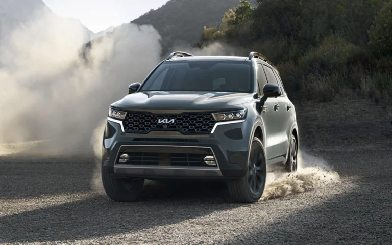 A Kia Sorento SUV on a dirt road kicking up dust.