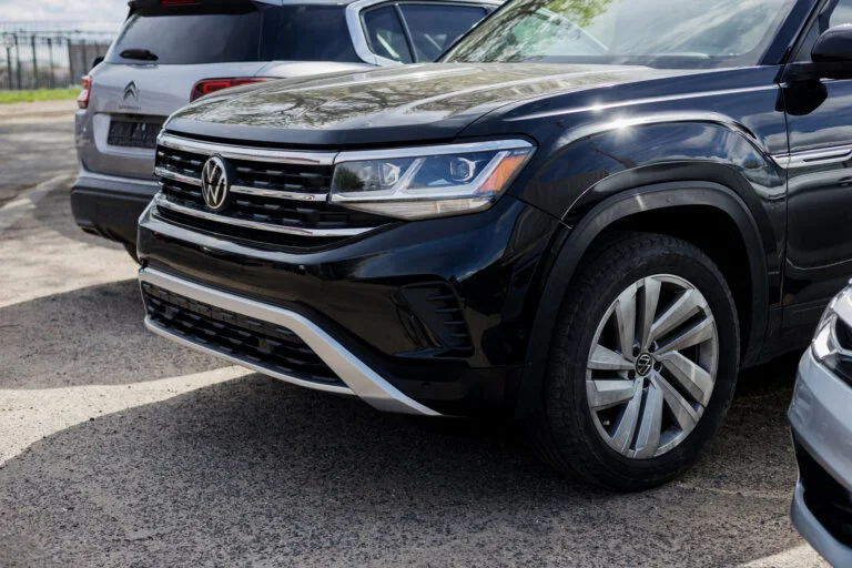 A partial view of a black Volkswagen Atlas is shown, with a silver Citroën SUV visible behind it.