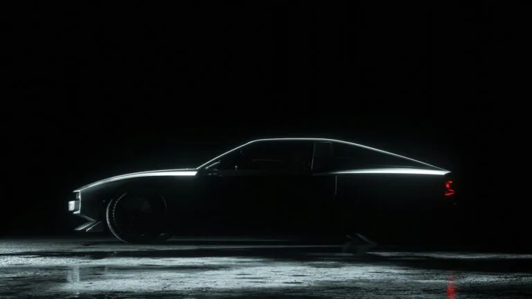 Dark side-profile view of a sleek car on a wet reflective surface.
